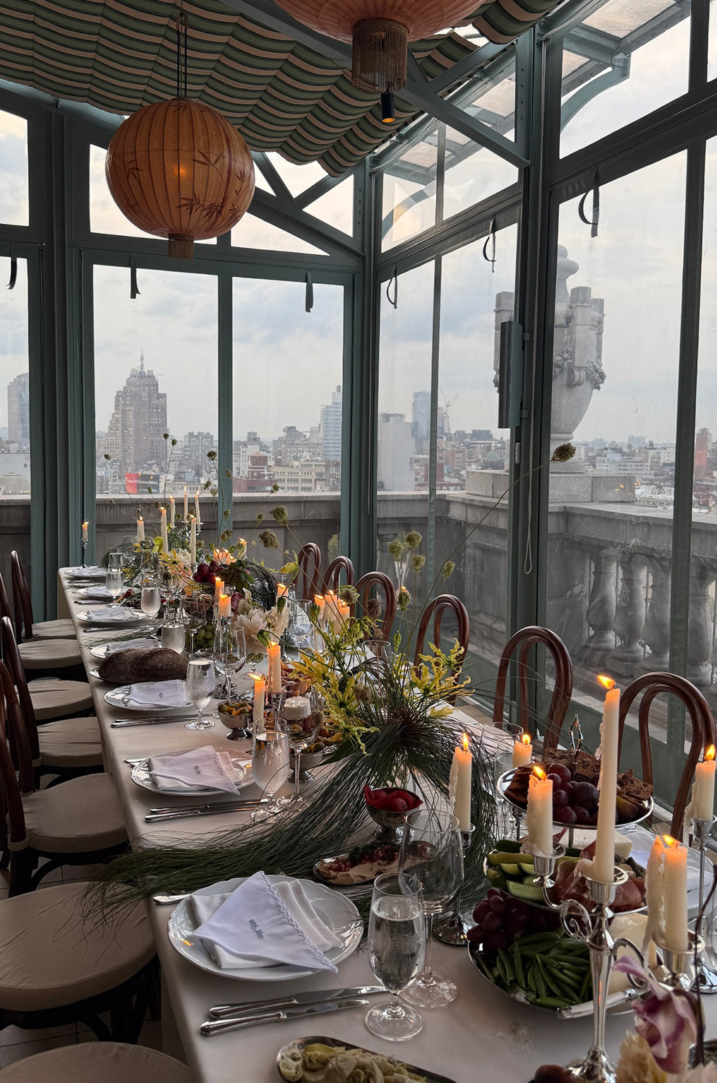 Dining table set beside large windows with a city view