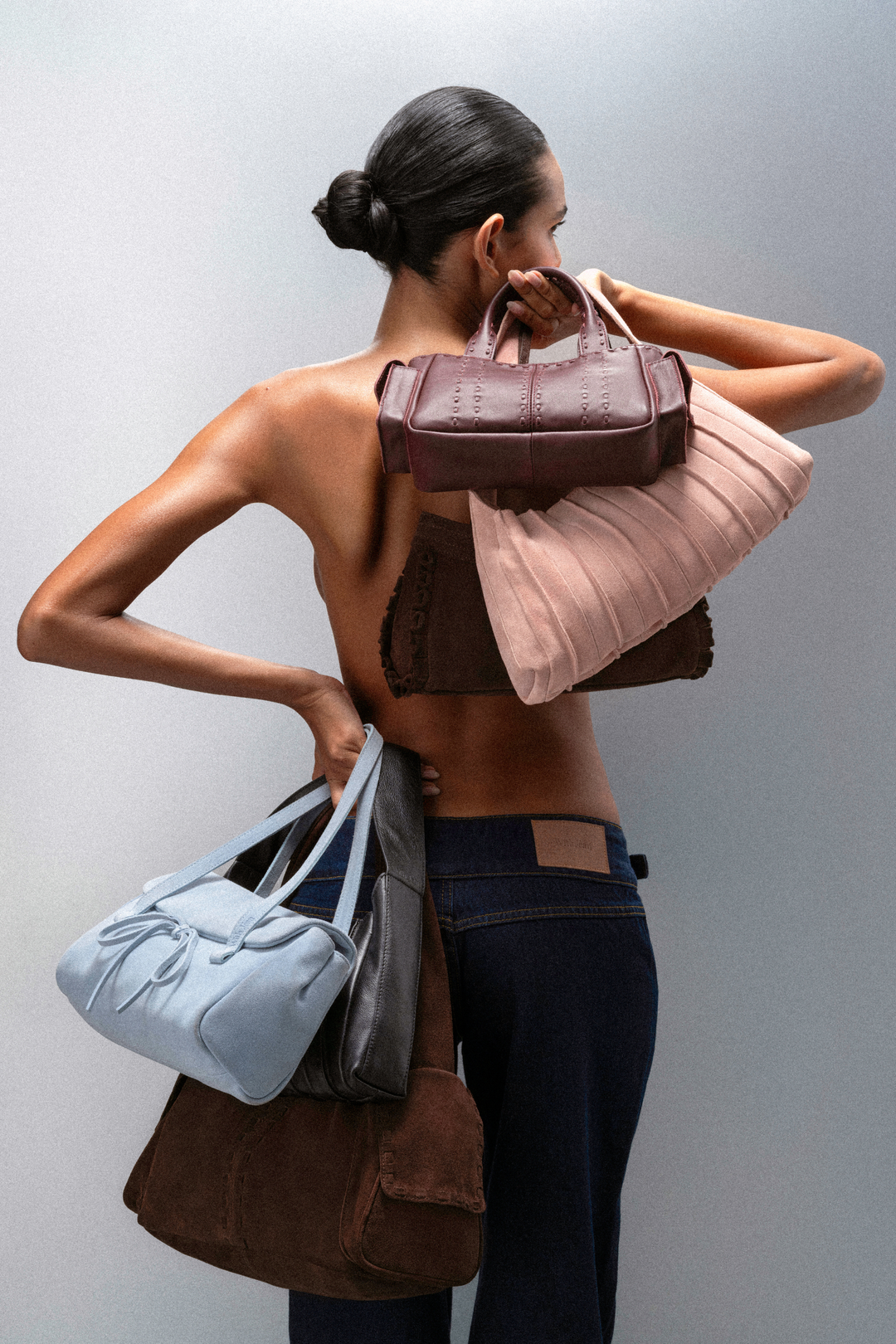 Model seen from behind carrying three shoulder bags