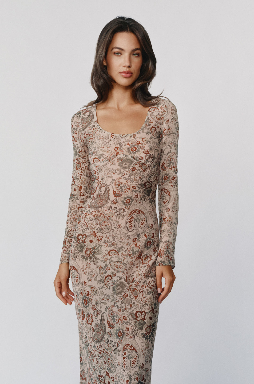 Josephine dress in stone paisley print with long sleeves, scoop neckline, and sheer finish on a model.