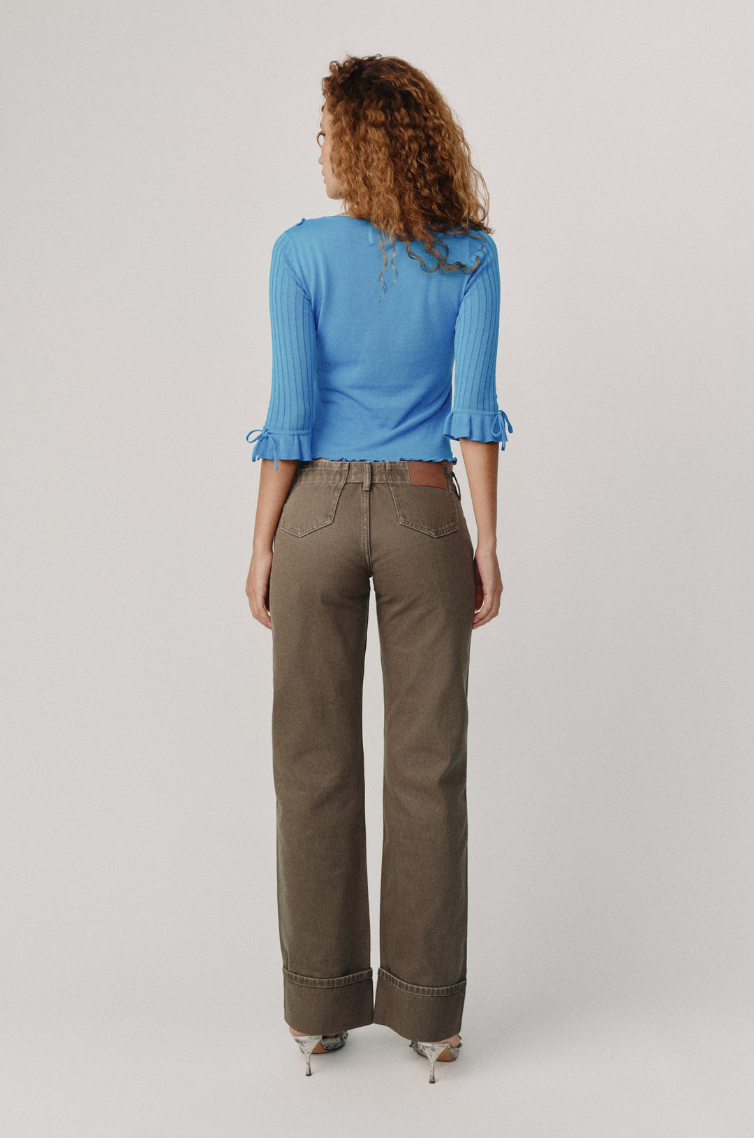 Alba low-rise Smoky Moss denim jeans with fixed cuffed hem, worn by a model from behind.