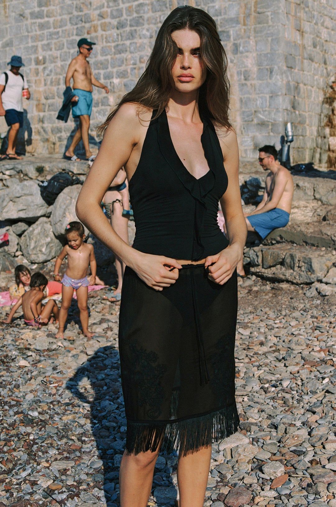 Black sheer low-rise Andie skirt with an adjustable drawstring waist, embroidered front detailing, and a fringe hemline.