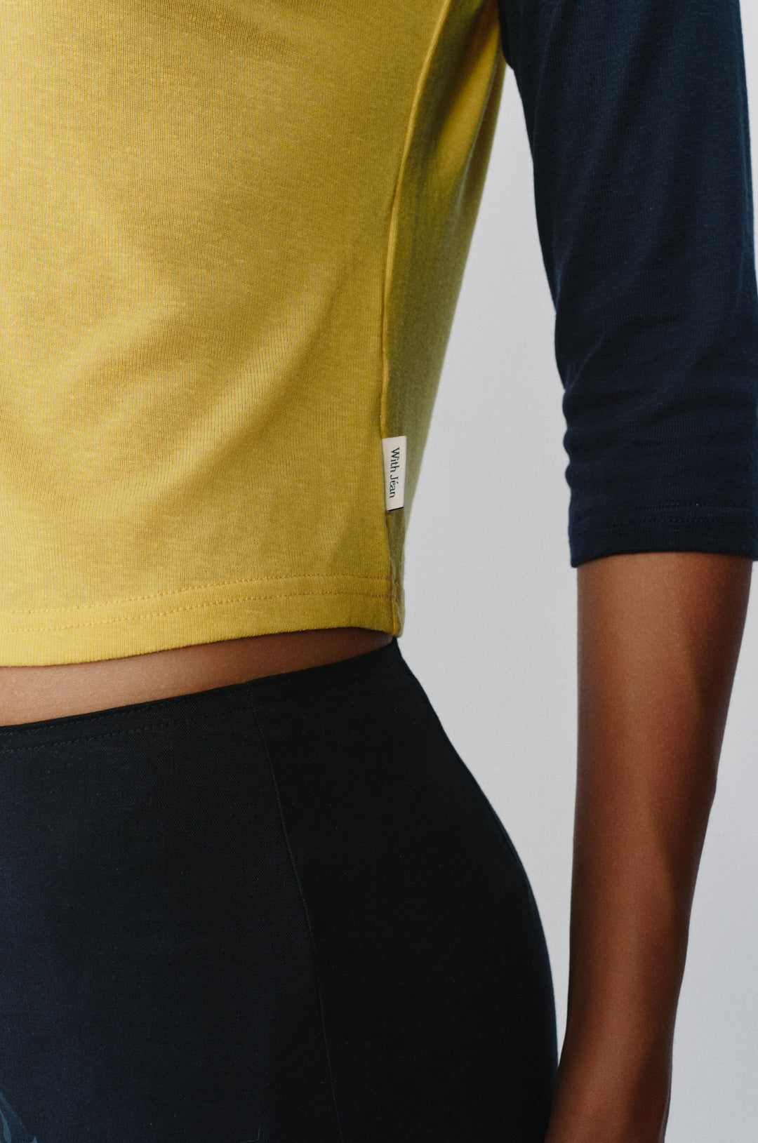 Yellow and midnight navy raglan tee with a relaxed fit and side logo tag.