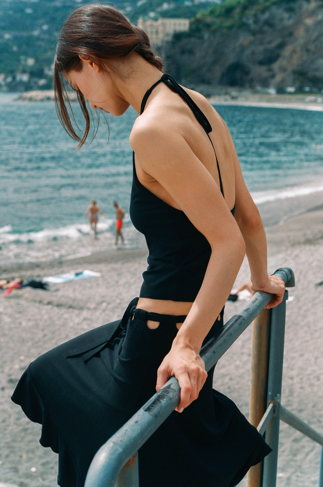 Black Carrie Skirt: low-rise midi with adjustable tie waistband, cut-out detail, and ruffle hem.
