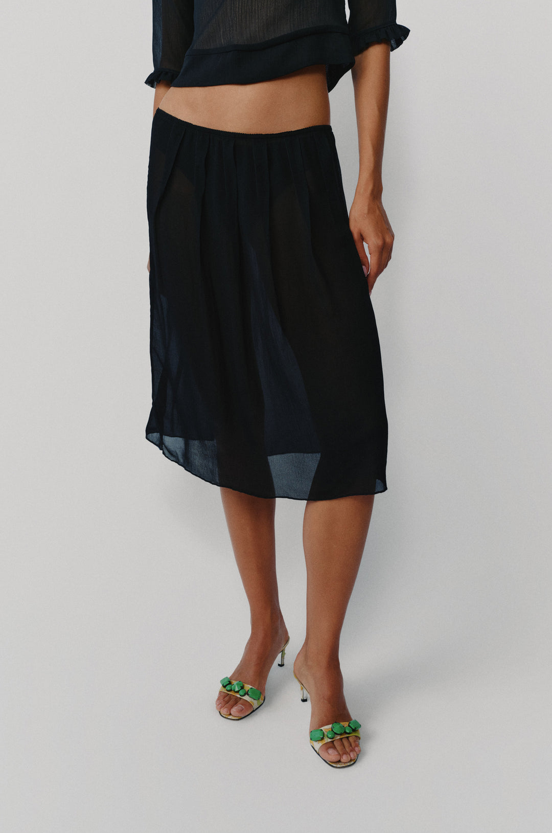Black low-rise midi skirt in a soft pleated silhouette with a picot-edge elasticated waistband.