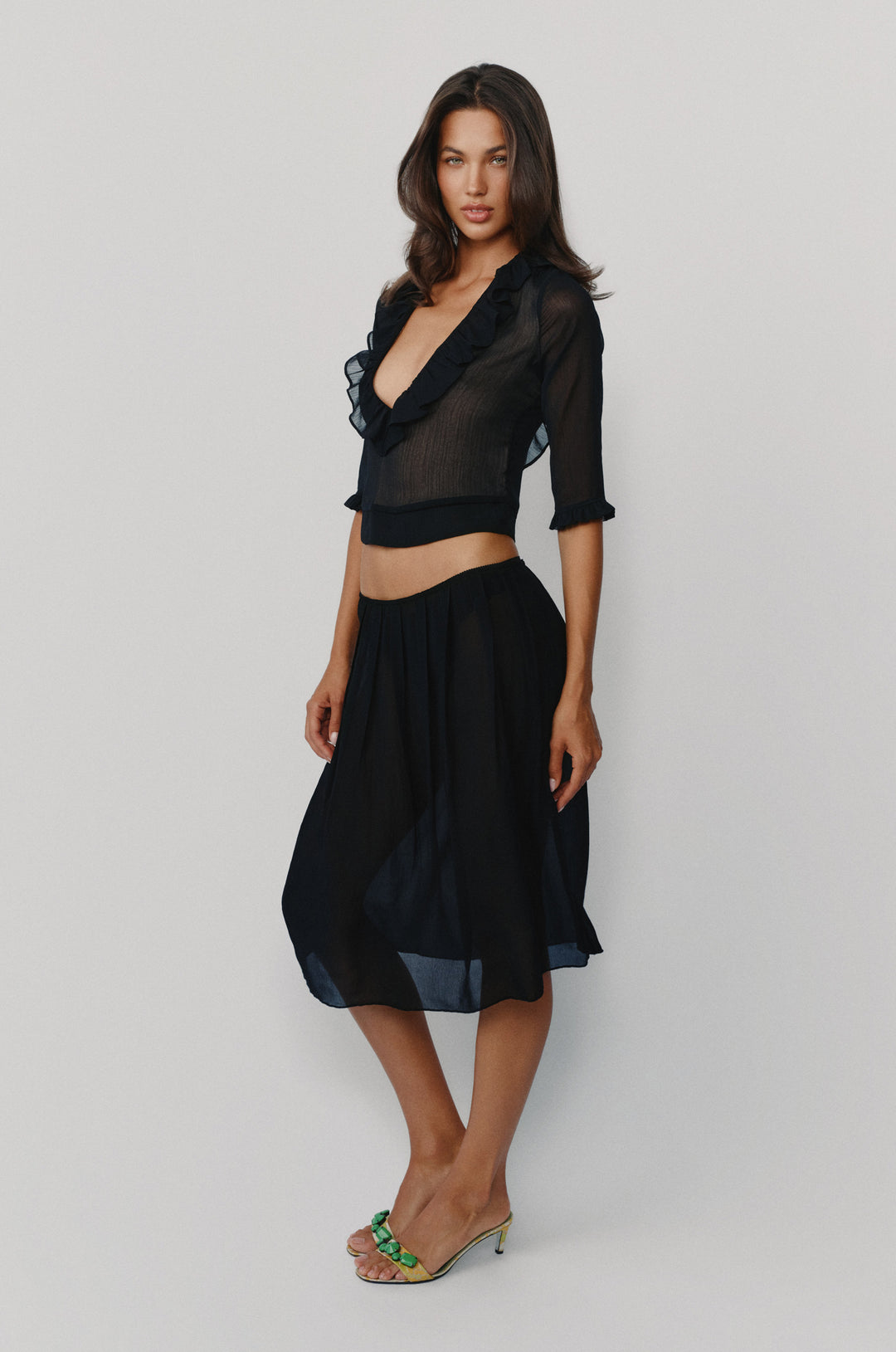 Black low-rise midi skirt with a soft pleated silhouette and picot-edge elasticated waistband.