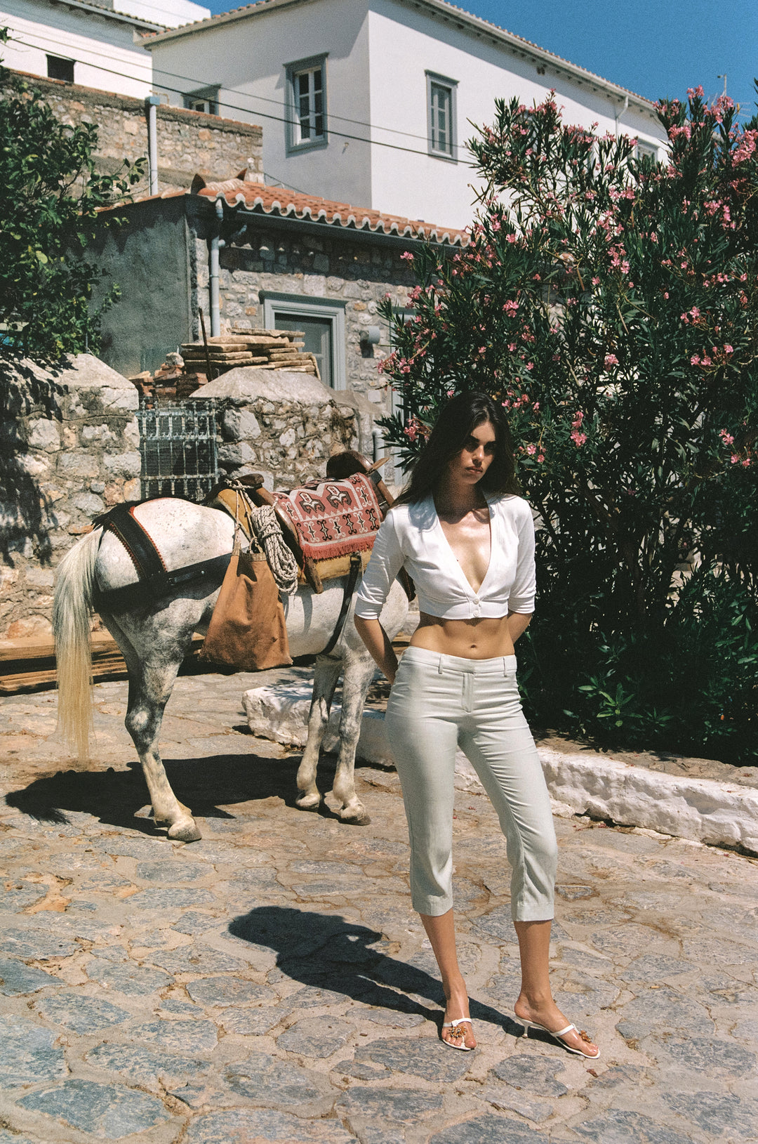 Dusty sage slim-fit Davis capri pants with a low-rise waist, front zip, and back seam detailing worn outdoors.