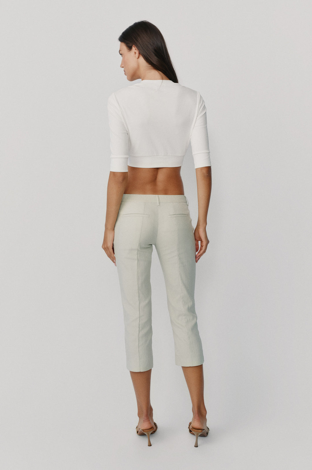 Back view of dusty sage Davis low-rise slim fit capri pants with back welt pockets and seam detailing.