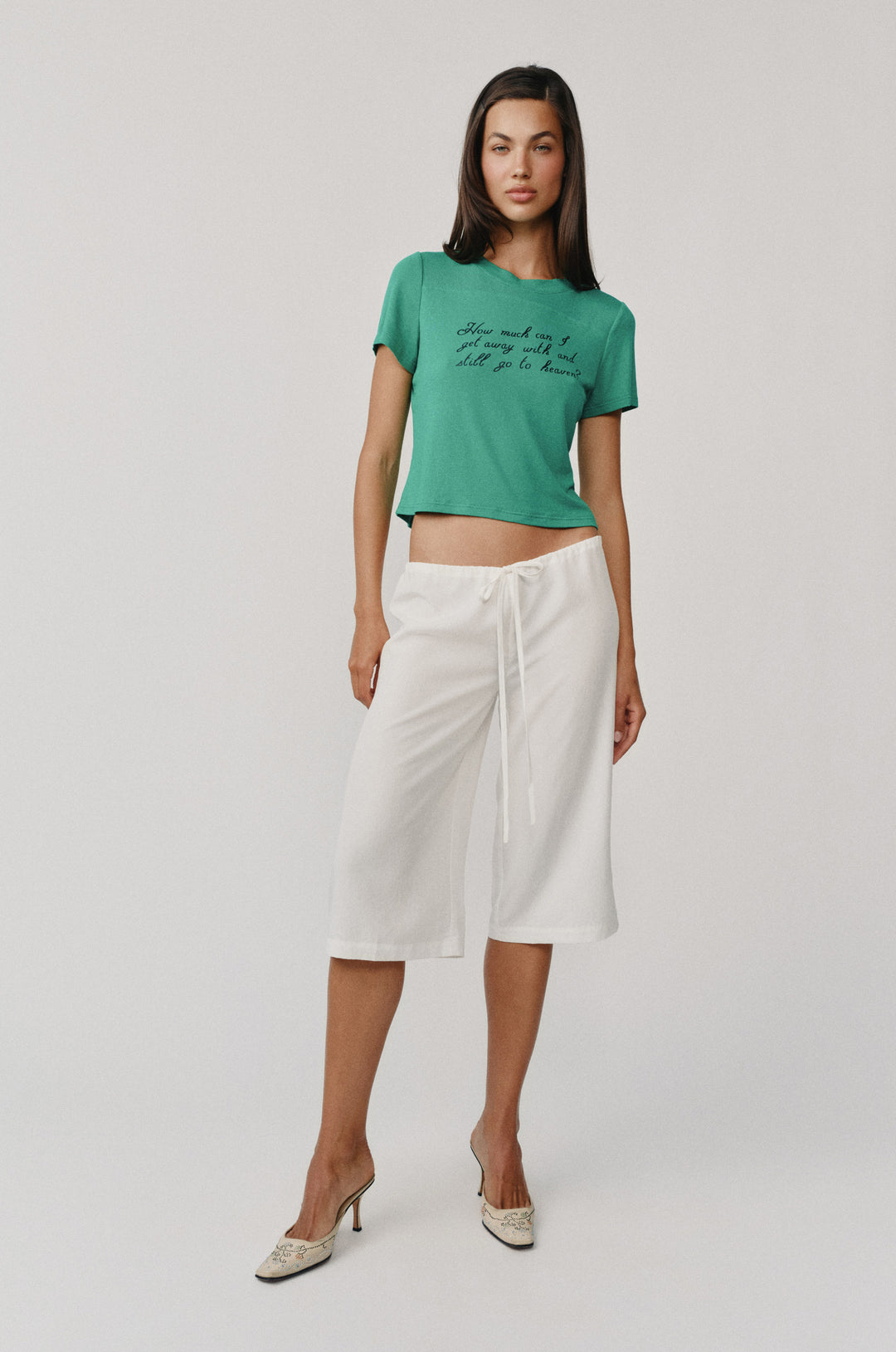 Ellie Tee in emerald green with black script, short sleeves, and round neckline, paired with white capris.