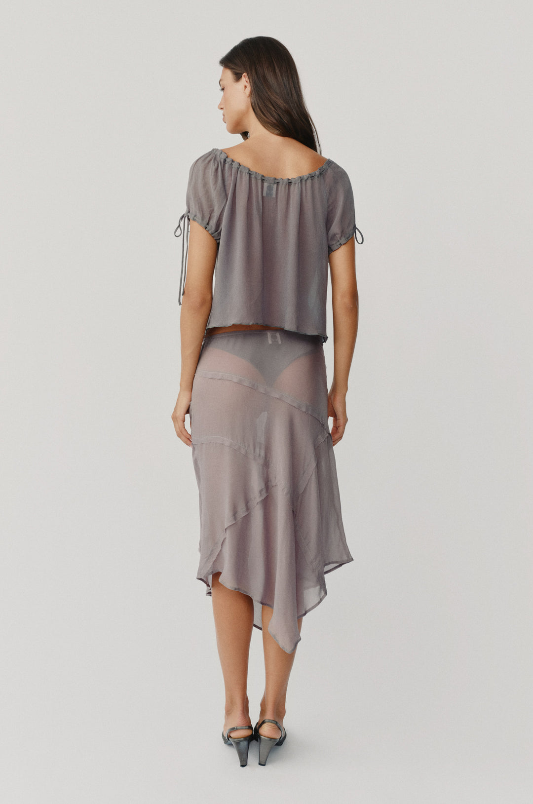 Dusty slate sheer low-rise Gia skirt featuring frayed-edge panel detailing and an asymmetrical hem.