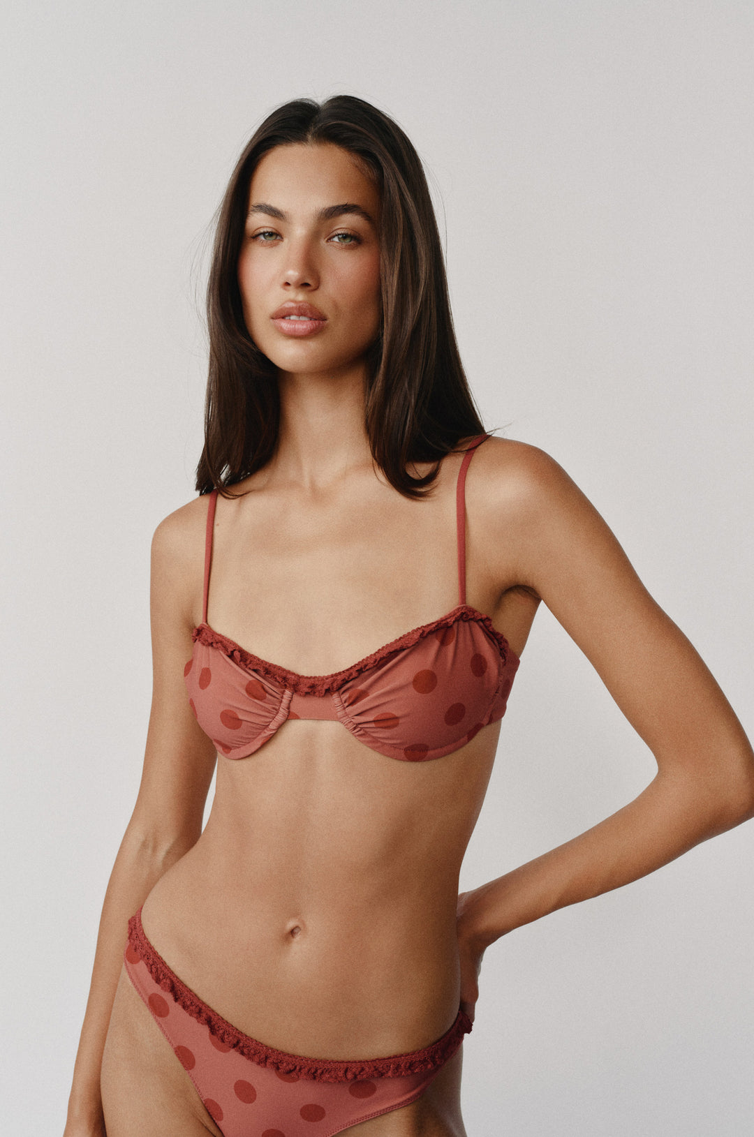 Jeanie Bikini Top in red big dot print, featuring underwire, balconette style, ruffle trim, and a contrast bow.