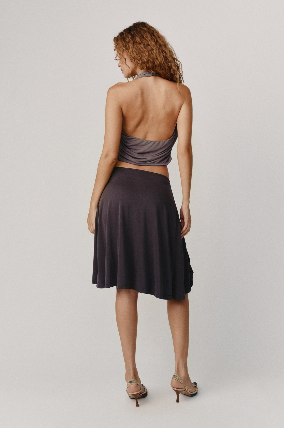 Jolene Skirt in Charcoal, a low-rise midi with adjustable tie waistband and side slit ruffle.