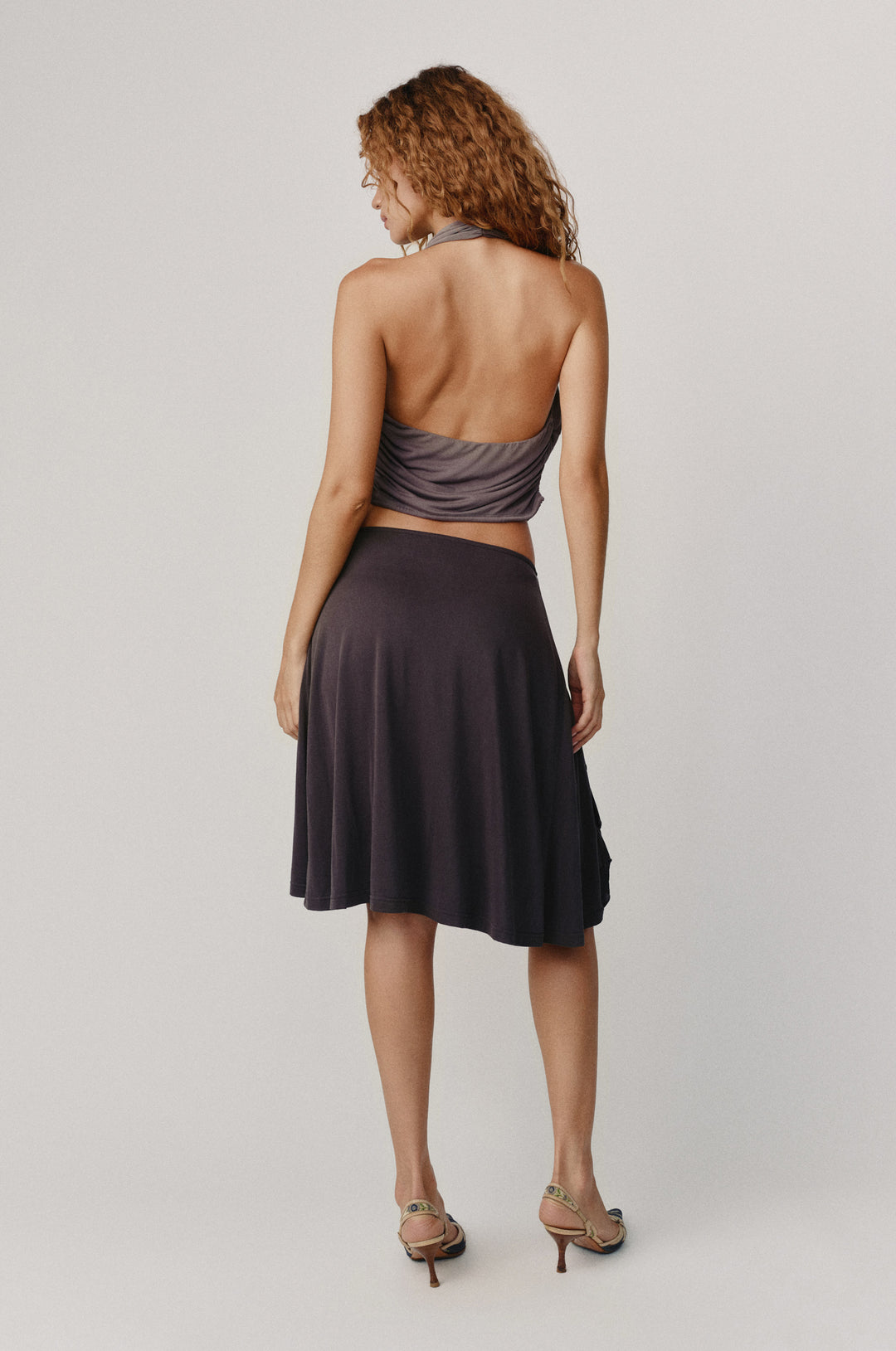 Jolene Top in slate, halter-style with ruched sides, adjustable tie, and low back, paired with a dark skirt.