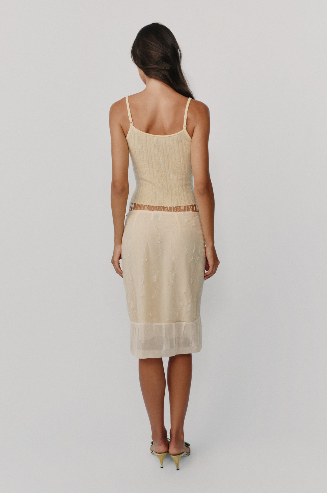 Pale yellow wool-knit Kayla top with delicate bead embellishments and a beaded fringe hem worn with a matching skirt.