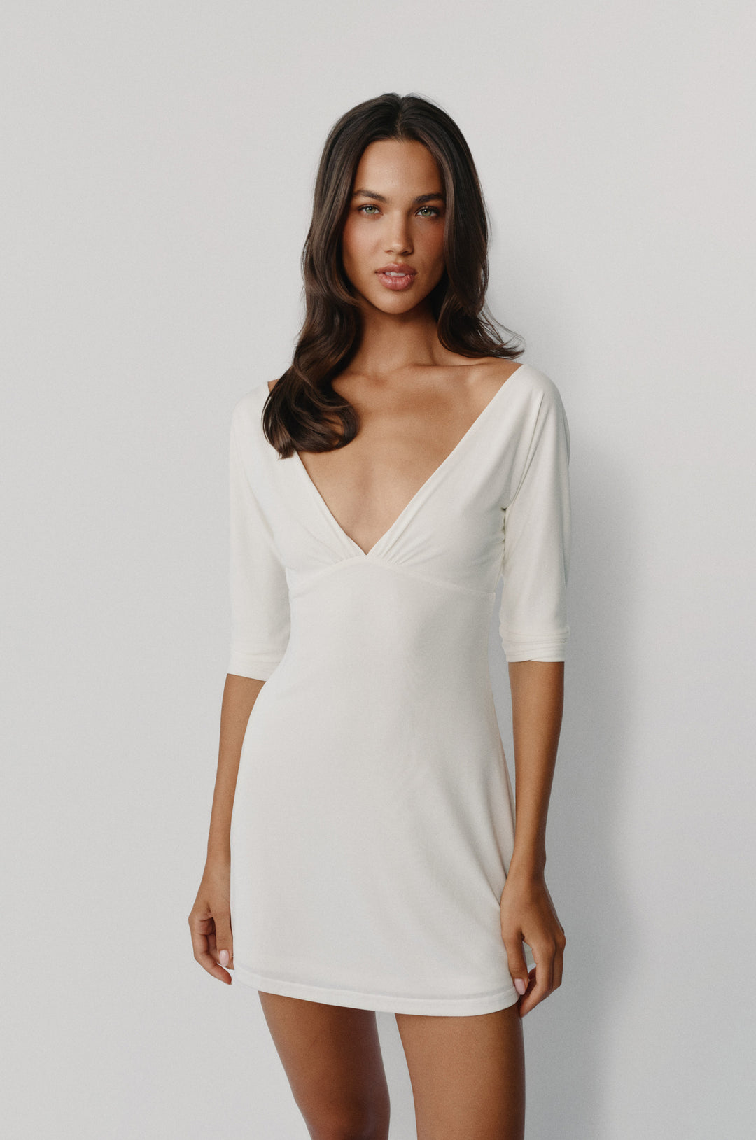 Off-white mini Lana dress with a V-neckline, half sleeves, and gathered bust detailing worn by a model.