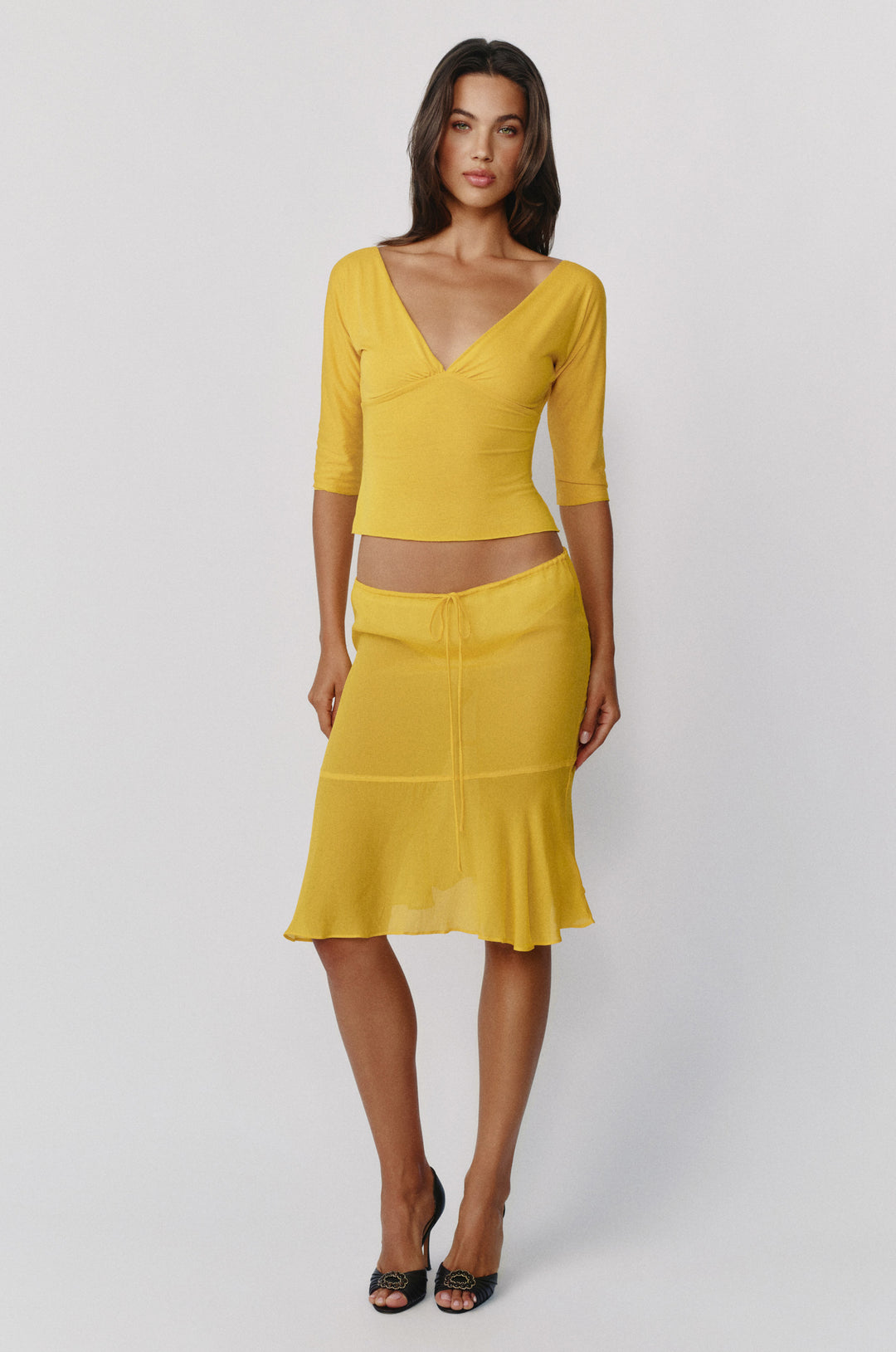 Golden yellow slim-fit Lana top with a V-neckline, half sleeves, and gathered bust detail worn with a matching skirt.