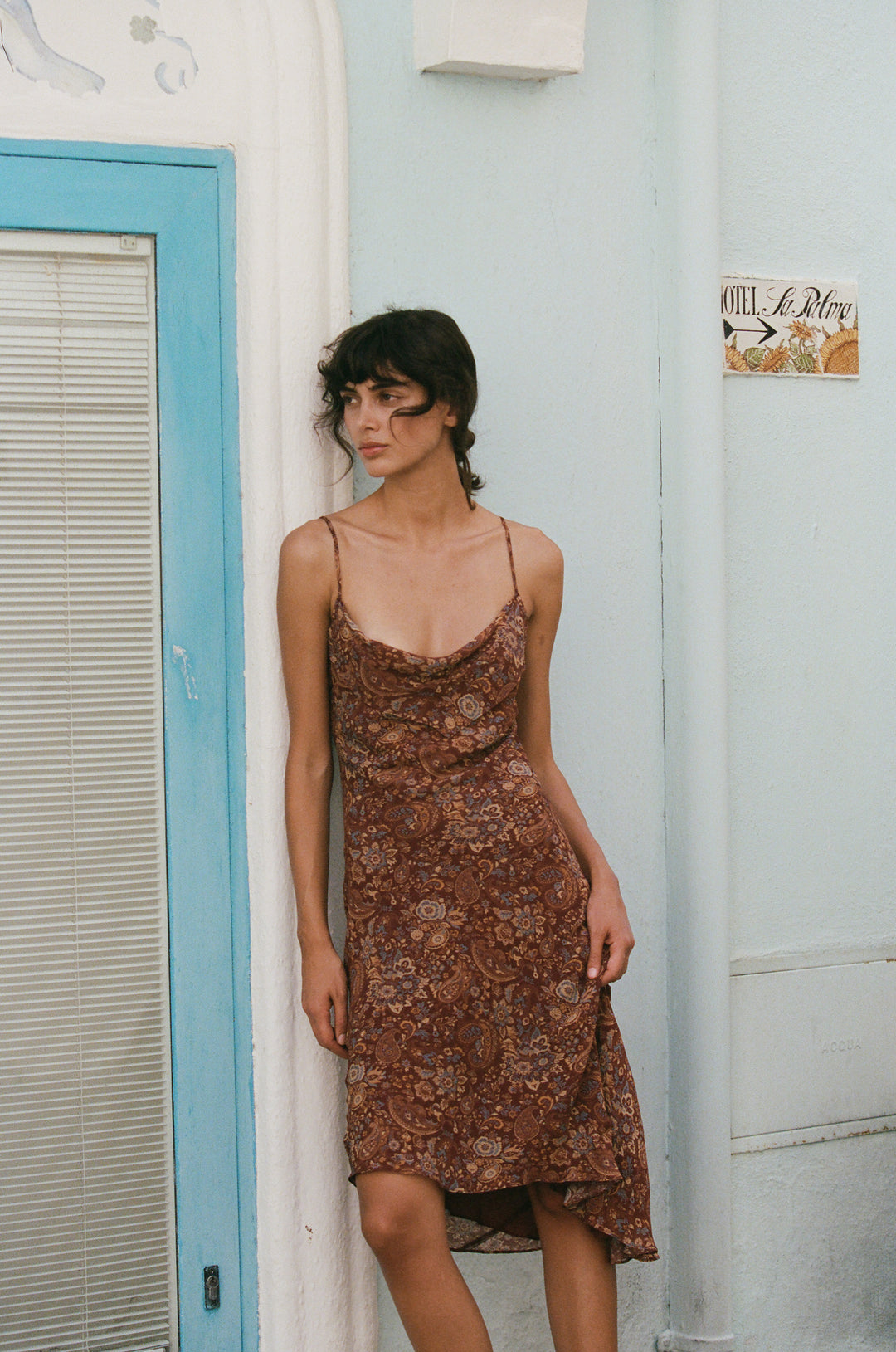 Mallory dress in terra paisley print with a cowl neck, thin straps, and an asymmetrical hemline.