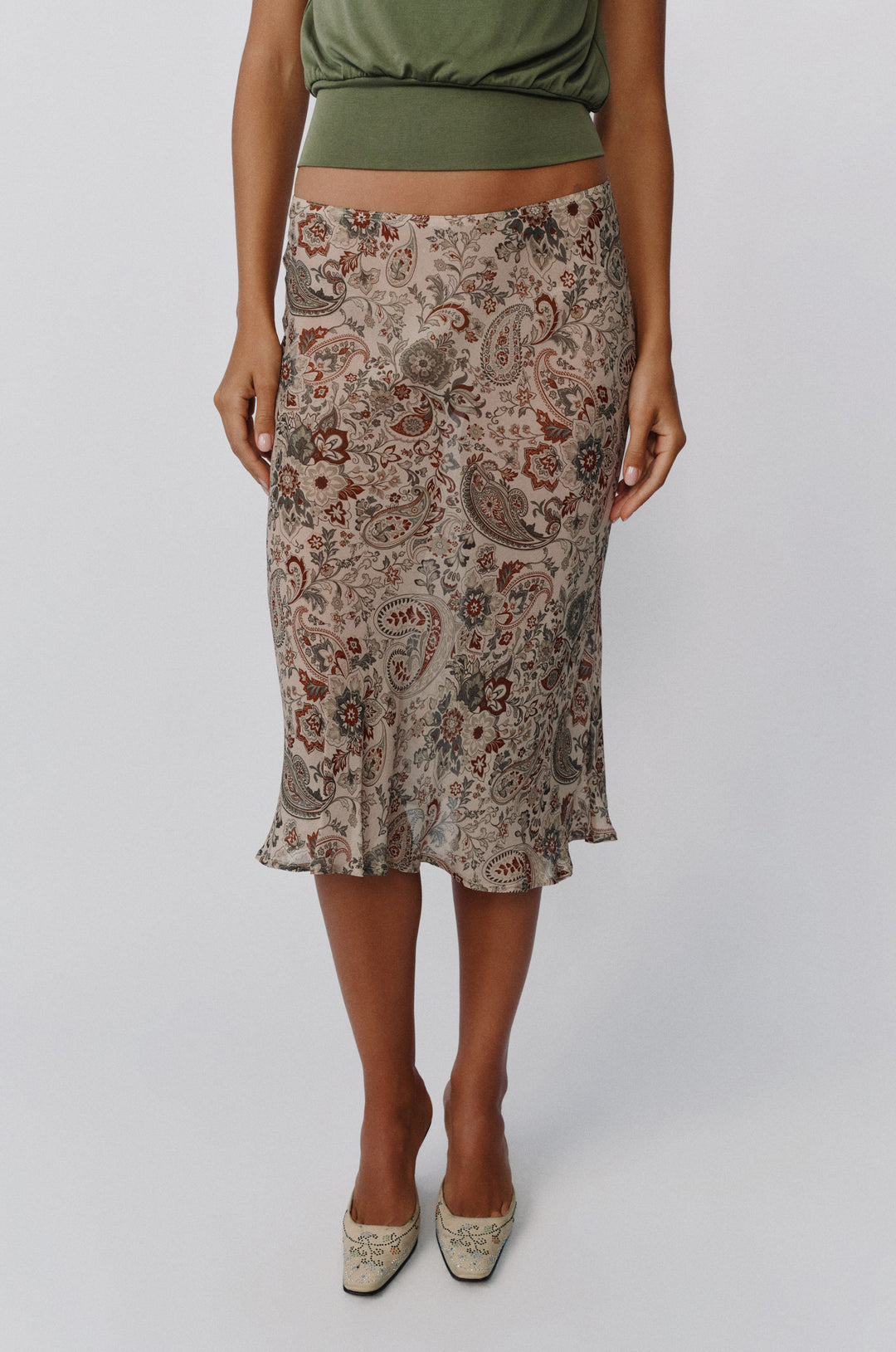 Olea midi skirt in stone paisley print with a sheer, low-rise fit paired with an olive green top.