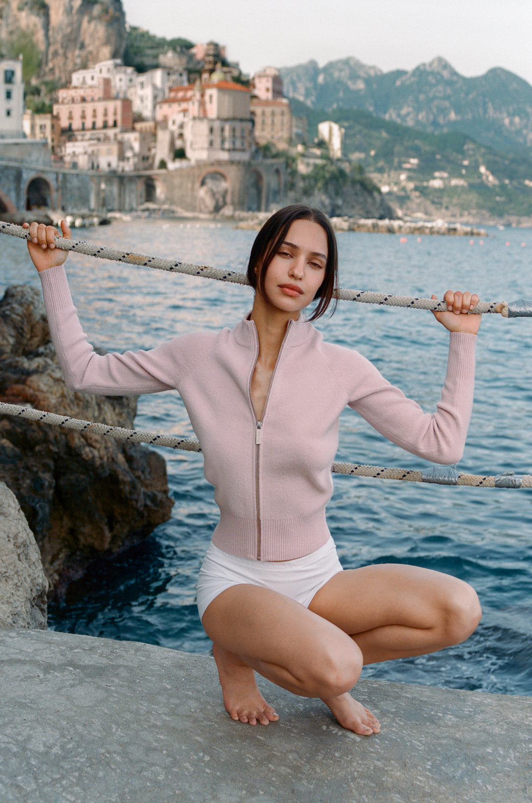 Pink Penelope Sweater, a knitted long-sleeve zip-up with a mock neck, raglan seams, and ribbed cuffs.
