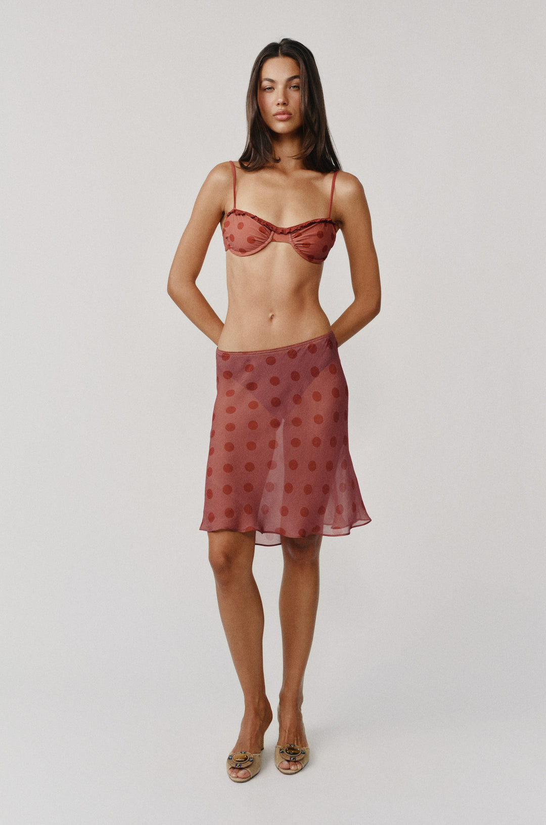 Model wearing a sheer red dot Penny Skirt with a matching low-rise, picot-edge elastic waistband.