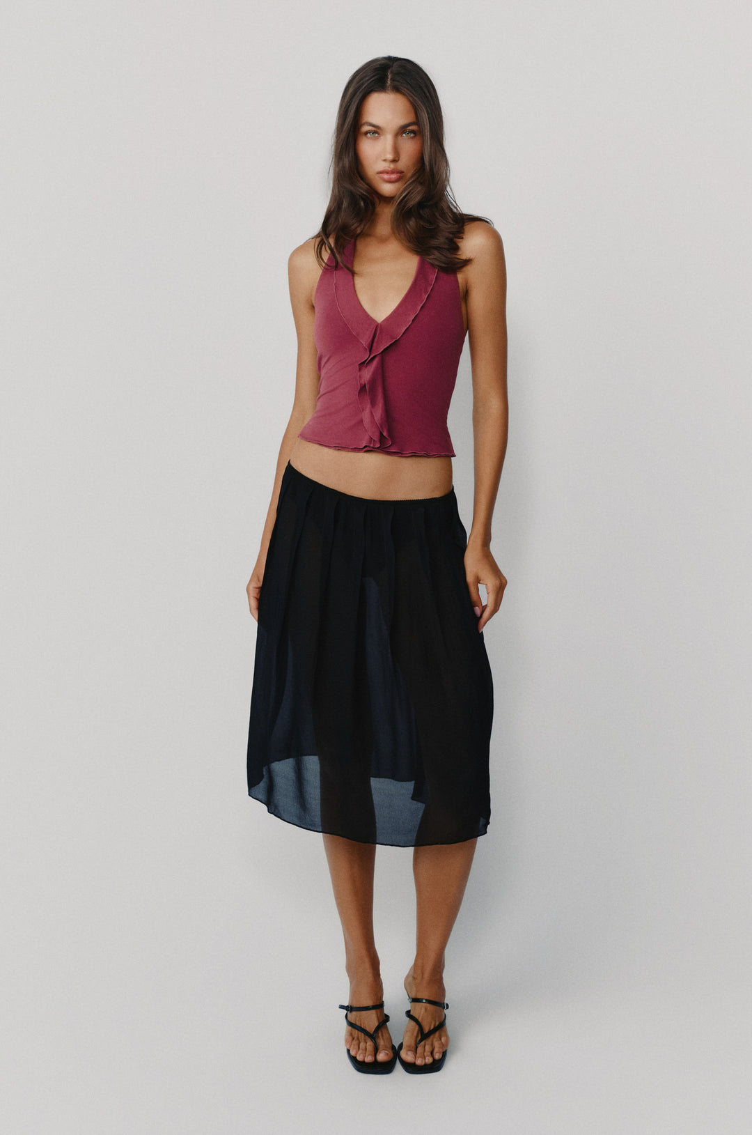 Plum halter-style Ruby top with ruffle-trim neckline and center front, paired with a sheer black midi skirt.