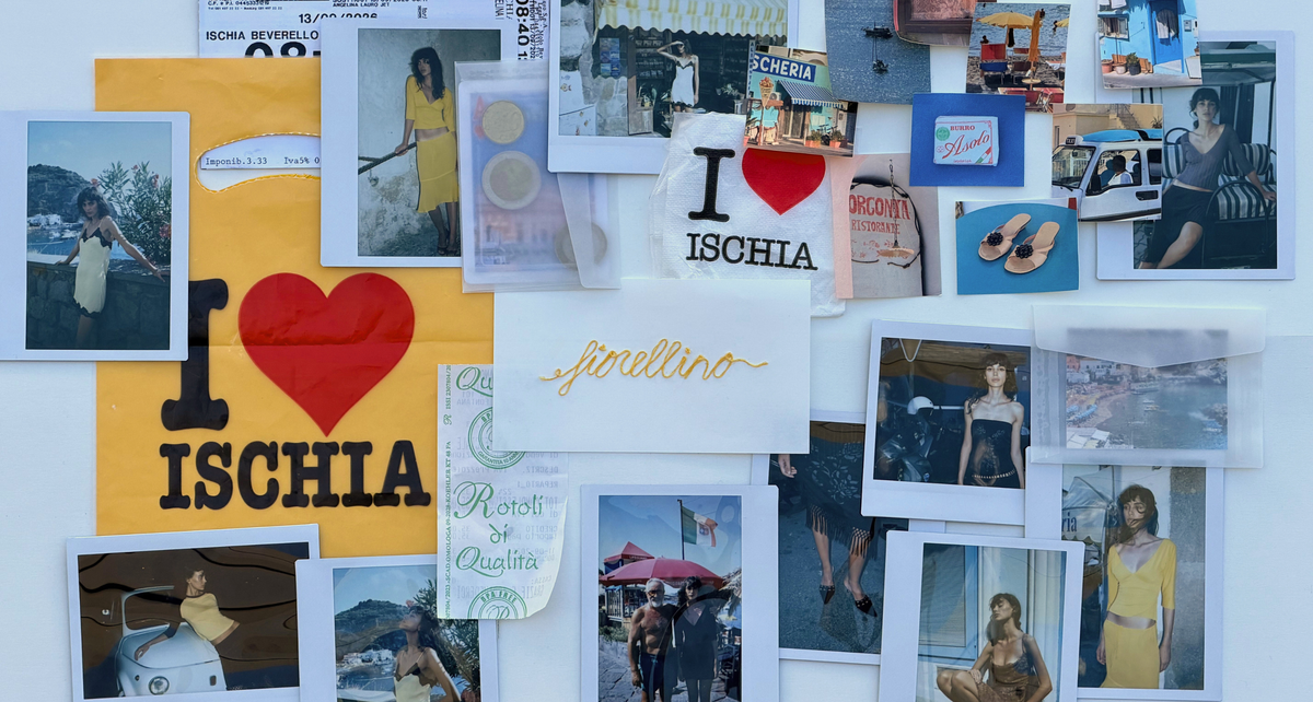 A collage of printed photos, cards, and a large yellow sign reading 'I ♥ ISCHIA' pinned against a white wall. The arrangement includes fashion photos, a white card with gold script reading 'Ischiana', and assorted printed memorabilia.