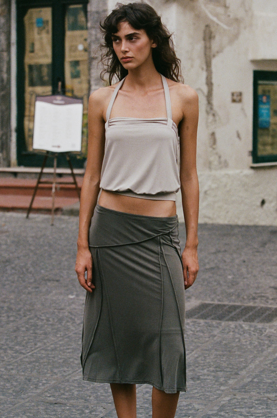 Slate grey midi-length Scout skirt with asymmetrical seam detailing and a low-rise elasticated waistband.
