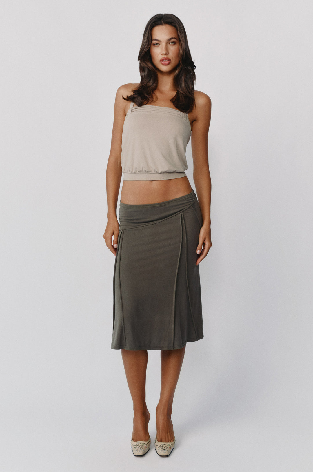 Slate midi-length Scout skirt worn low on the hips with asymmetrical seam detailing and an elasticated waistband.