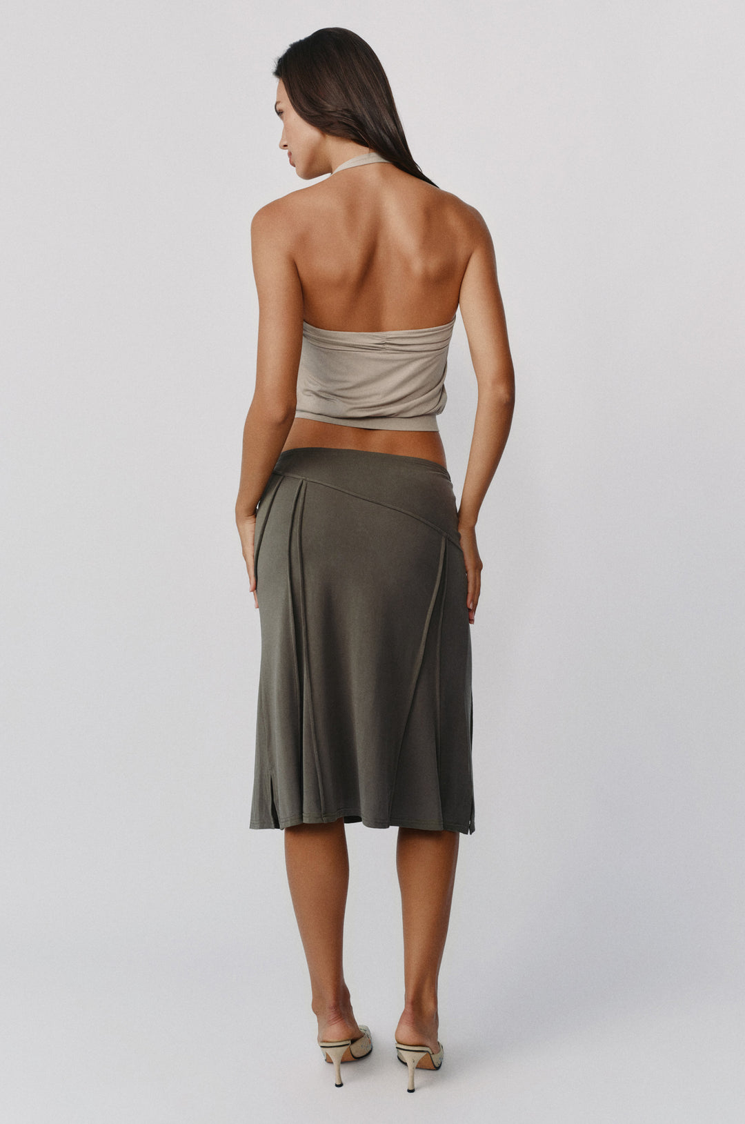 Slate grey midi-length Scout skirt worn low on the hips with asymmetrical seam detailing and an elasticated waistband.