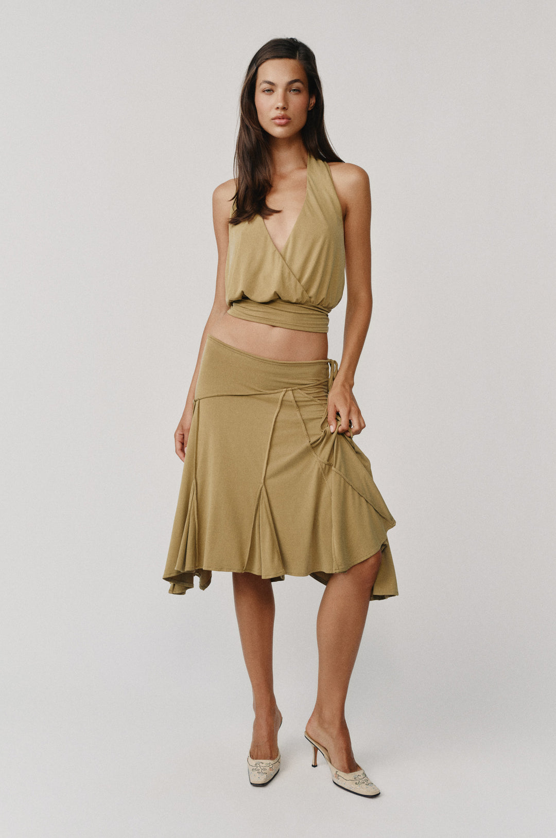 Olive Sharni midi skirt worn low on hips with adjustable tie waistband, paired with a matching halter top.