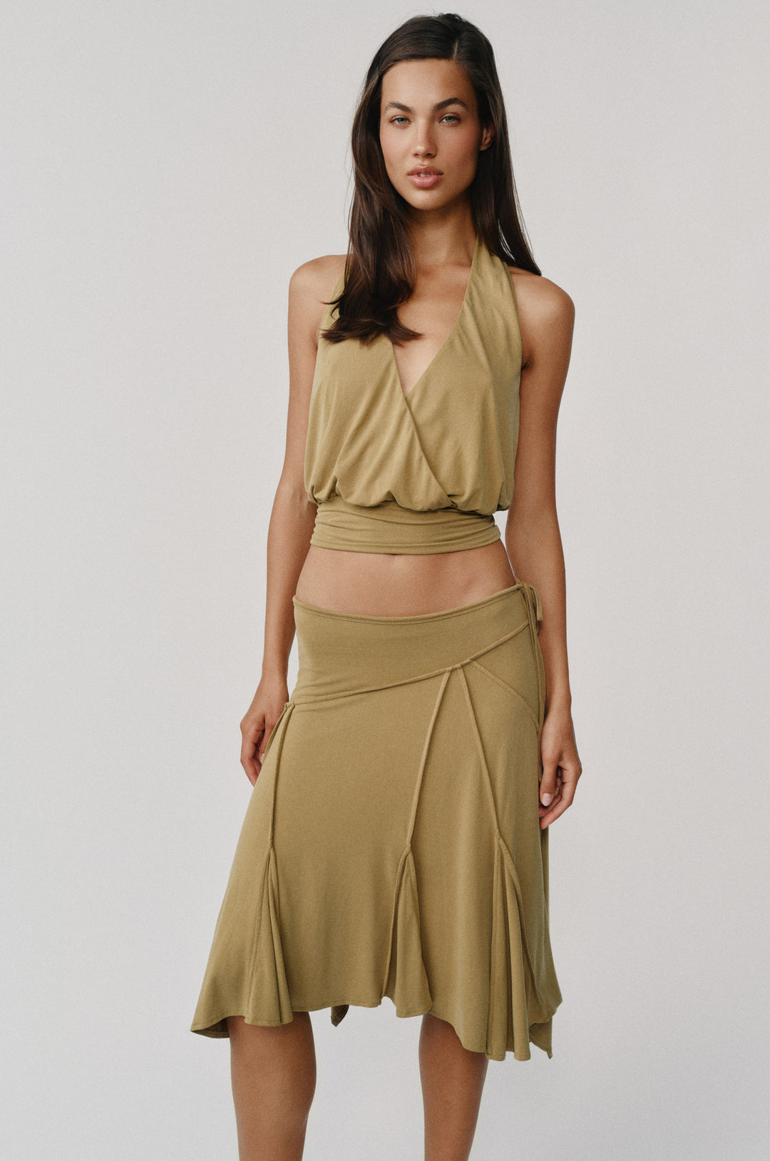 Model wearing an olive midi-length Sharni Skirt with an adjustable tie waistband, worn low on the hips.