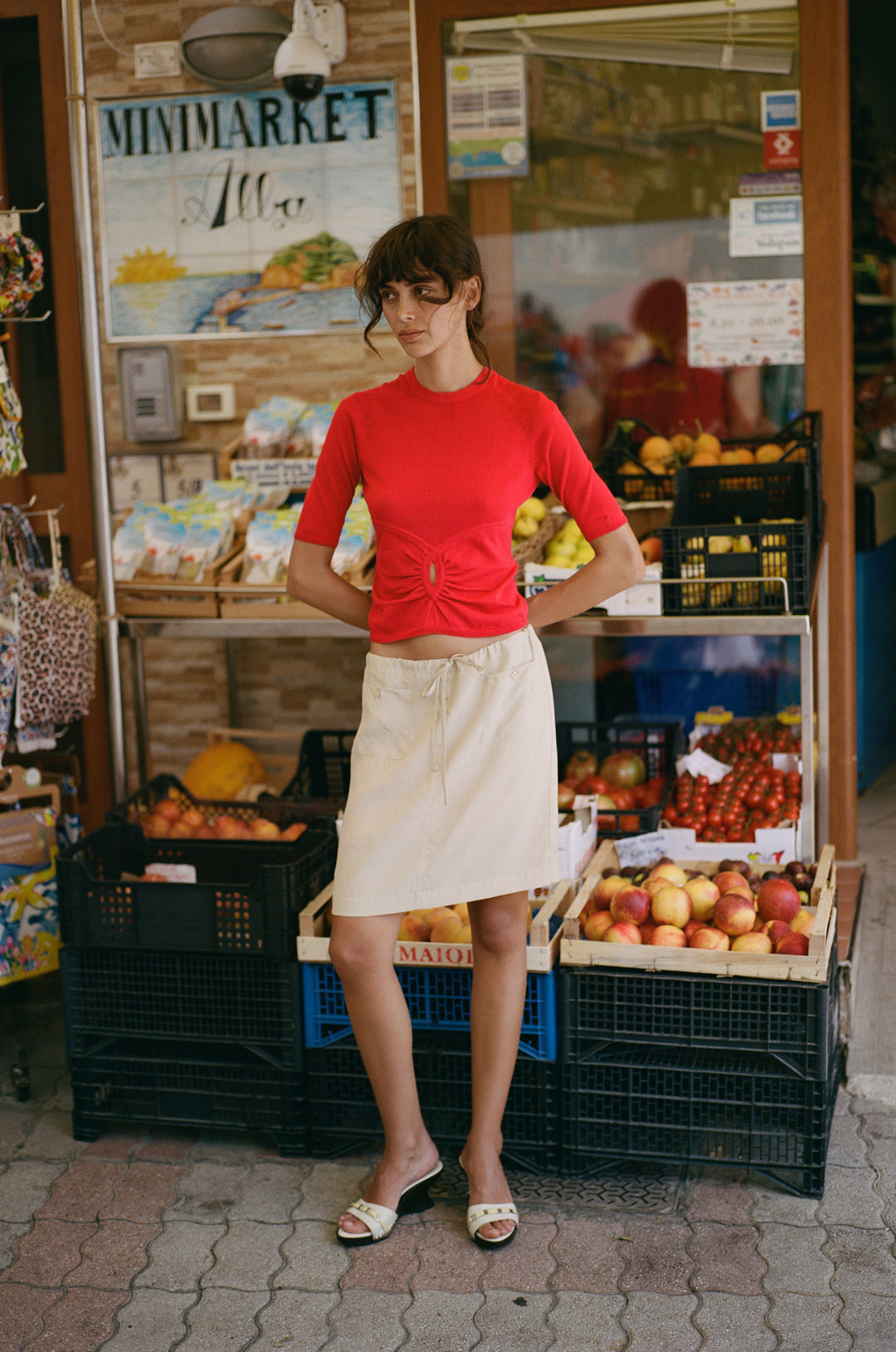 Beige low-rise Thea skirt with an adjustable drawstring waist, front patch pockets, and button detailing.